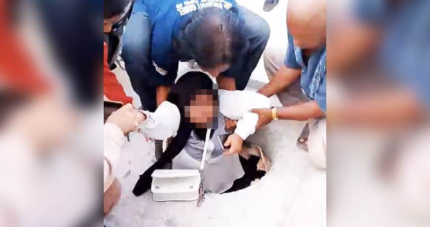 Tangkapan layar seorang wanita sedang dibantu oleh masyarakat karena terperosok ke lubang trotoar di depan Kantor Nasdem, Kelurahan Hutuo, Kecamatan Limboto, Kabupaten Gorontalo yang viral di media sosial, Sabtu(2/11).