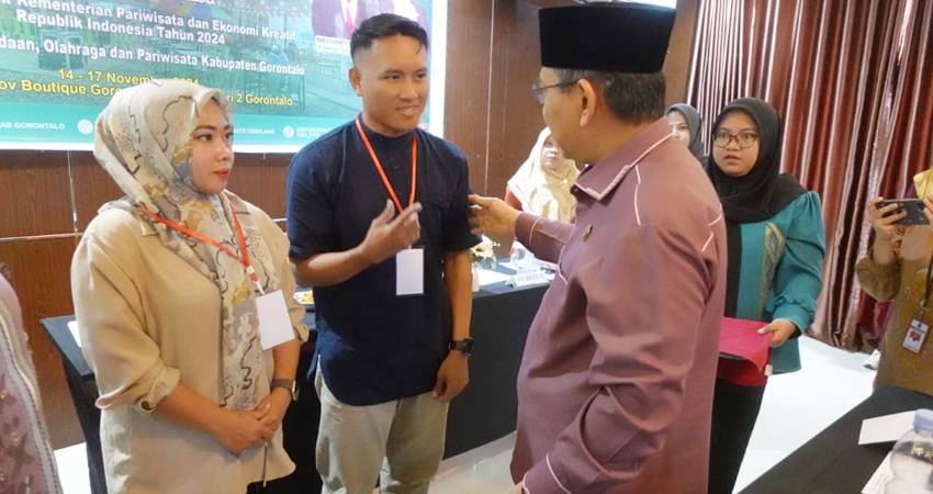 BUKA. Pjs Bupati Gorontal Syukri Botutihe saat menyematkan tanda peserta secara simbolis seusai membuka kegiatan tersebut.