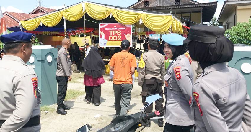 JAGA JARAK - Sejumlah petugas kepolisian saat memantau pelaksanaan pemungutan suara di salah satu TPS di Kota Gorontalo.