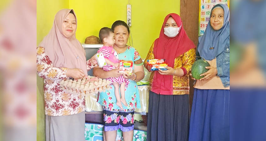 Ketua PKK Kecamatan Dungingi, Meilan Daud tengah menyerahkan bantuan kepada salah seorang anak penderita stunting, Kamis (14/11/2024).