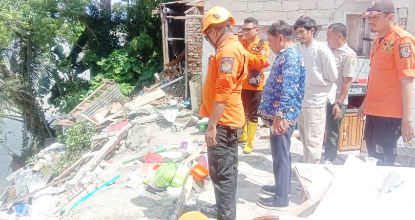 Pasukan BPBD Kota Gorontalo ketika meninjau kondisi rumah yang tertimpa longsor di Kelurahan Botu, Kecamatan Dumbo Raya, Selasa (17/12/2024). (Foto: BPBD)