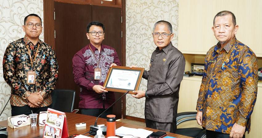 Pj Wali Kota Gorontalo, Ismail Madjid ketika menerima hasil penilaian pelayanan publik dari Ombudsman RI perwakilan Gorontalo, Jumat (20/12/2024). (Foto: Prokopim)