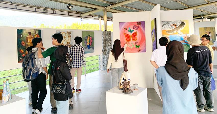 Pengunjung saat melihat lukisan yang dipamerkan di Gerbang kampus 4 UNG, Rabu (18/12/2024)