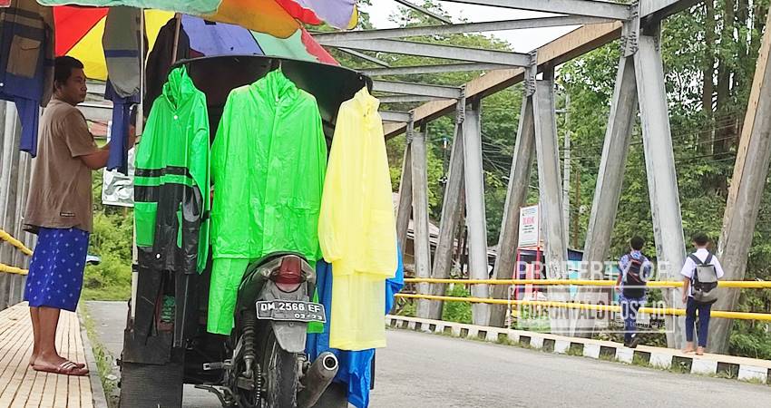 LARIS MANIS Musim hujan penjual jas hujan di Jembatan Potanga, Kecamatan Kota Barat, Kota Gorontalo, mengais rejeki. (F. Natha/ Gorontalo Post)