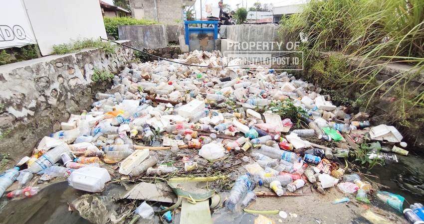 TERSUMBAT - Tumpukan Sampah menyumbat di saluran air atau drainase, di Desa Toto Selatan, Rabu (22/1/2025). ( Foto Natha/ Gorontalo Post).