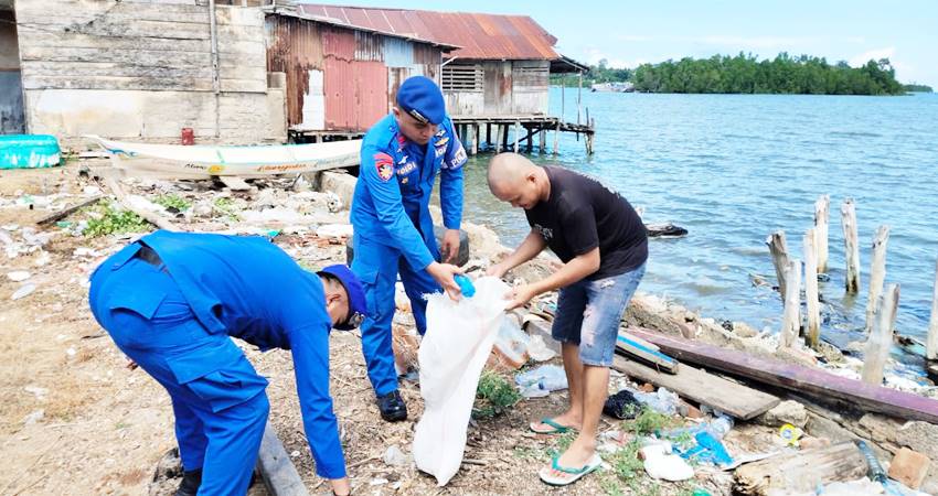 Petugas Dit Polairud Polda Gorontalo dibantu warga saat memungut sampah di pesisir pantai di wilayah Gorontalo.
