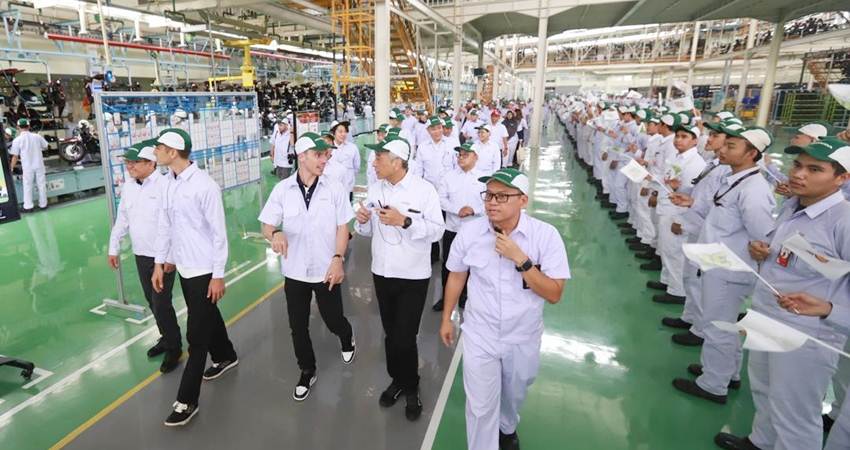 Pebalap MotoGP Joan Mir dan Luca Marini (tengah) berfoto bersama jajaran manajemen dan karyawan PT Astra Honda Motor saat mengunjungi pabrik produksi sepeda motor Honda PCX di Deltamas (1/2). (Foto : dok/ahm)