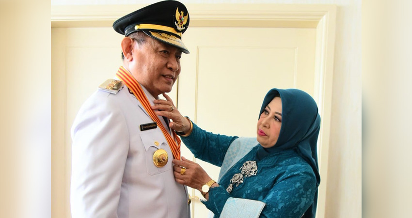 Gubernur Gusnar Ismail disematkan lencana melati tanda penghargaan Pramuka pada pakaian dinas upacara oleh istrinya, Nani Mokodongan sebelum pelantikan di Jakarta, Kamis (20/2). (foto : dok / diskominfotik)