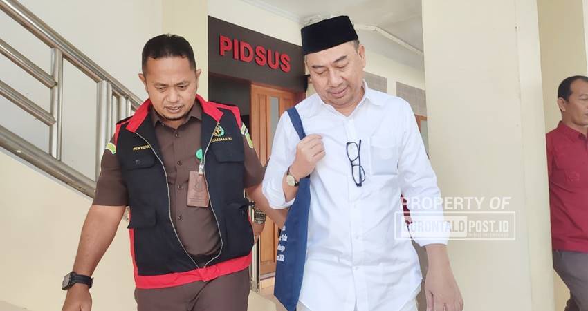 Mantan Bupati Bone Bolango Hamim Pou keluar dari ruang pemeriksaan Pidsus Kejati Gorontalo menuju Kejari Bone Bolango, Rabu (26/2/2025).(Foto : Natha/Gorontalo Post)