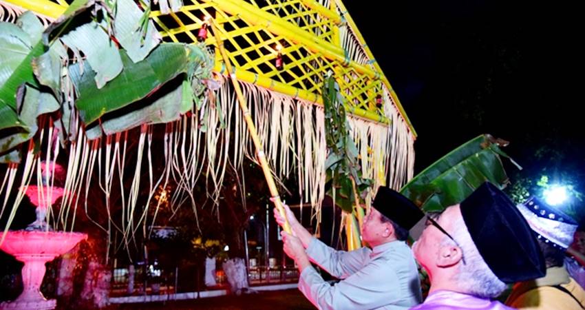 Gubernur Gusnar Ismail menyalakan lampu botol yang digantung pada alikusu atau gerbang adat yang menandai perayaan malam tumbilotohe di halaman rumah jabatan gubernur, Rabu (26/3). (Foto : Haris / diskominfotik)