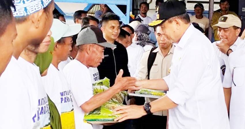 Gubernur Gorontalo Gusnar Ismail menyerahkan bantuan benih kepada petani saat kunjungan kerja di Desa Suka Makmur Utara, Kecamatan Tolangohula, Kabupaten Gorontalo, Rabu (19/3). (Foto : Rian/diskominfotik)