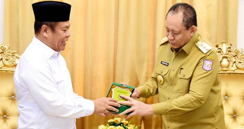 Gubernur Gorontalo Gusnar Ismail (kanan) menerima cinderamata berupa plakat dari Rektor IAIN Sultan Amai Gorontalo, Zulkarnain Suleman, disela pertemuan di rumah jabatan Gubernur, Senin (17/3). (Foto : Haris/diskominfotik)