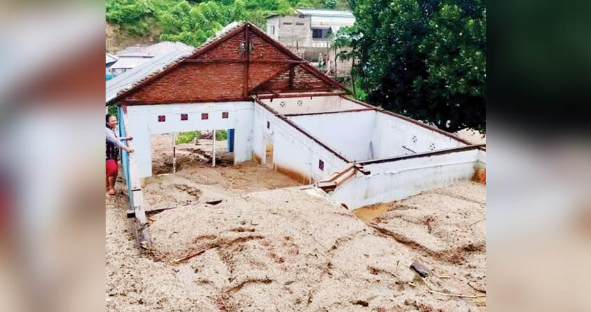 BUTUH PENANGANAN - Rumah warga di Kelurahan Talumolo, Kota Gorontalo, nyaris tenggelam tertimbun material longsor yang terjadi sejak Kamis (6/3) sore. (foto : istimewa)