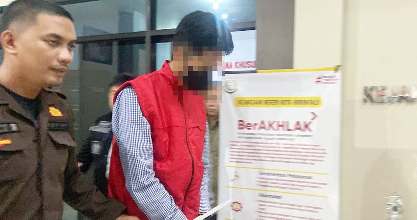 Direktur PT Raja, AA saat keluar dari ruangan pemeriksaan dan digiring menuju mobil tahanan, Selasa (18/3/2025) (F. Diyanti/Gorontalo Post)