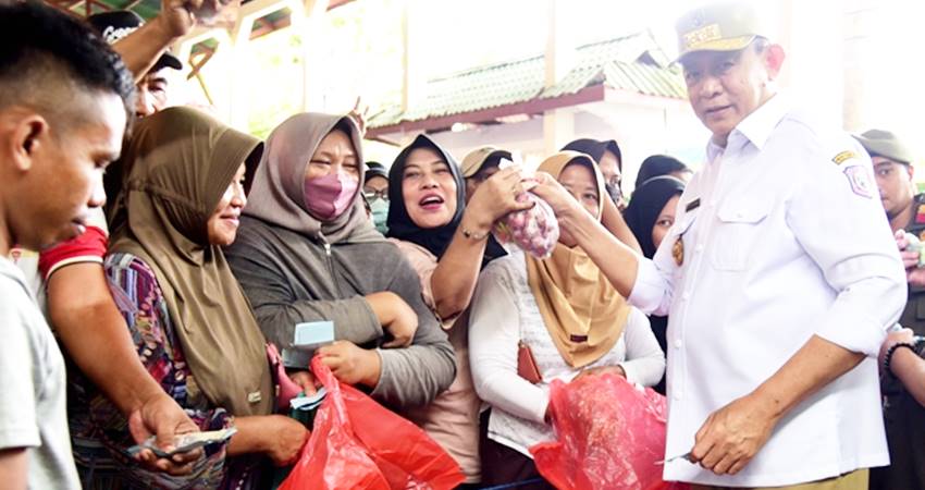 Gubernur Gusnar Ismail melayani warga yang berbelanja kebutuhan pokok pada pasar murah bersubsidi di Kecamatan Limboto, Kabupaten Gorontalo, Kamis (6/3). (Foto : Haris/Diskominfotik)