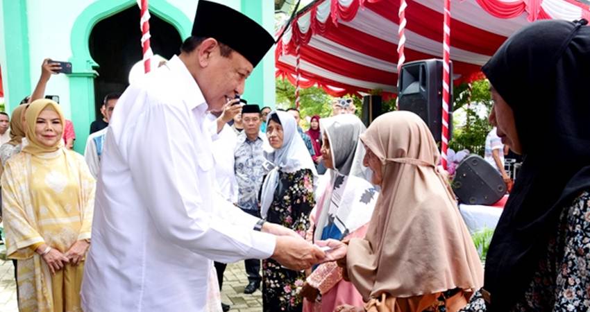 Gubernur Gusnar Ismail memberikan bingkisan kepada masyarakat Desa Reksonegoro pada pelaksanaan Festival Ketupat tahun 2025, Senin (7/4). (Foto : Haris/diskominfotik)