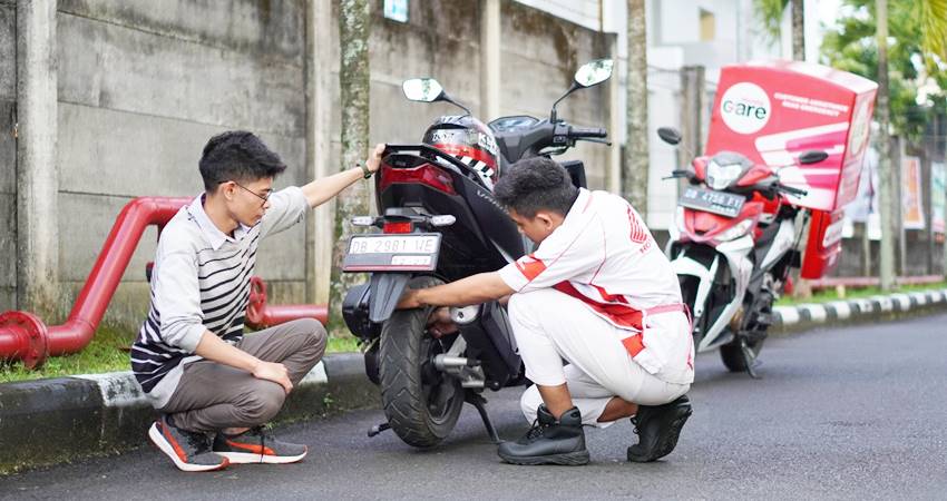 JADI SOLUSI - Teknisi sepeda motor honda dari layanan Honda Care saat menangani sepeda motor yang memiliki kendala. (foto : dok / daw)