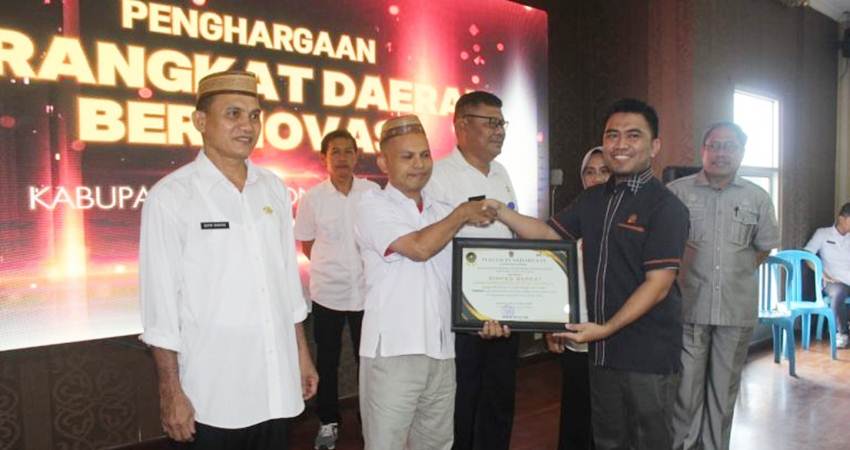 Anggota DPRD Gorut Windra Lagarusu saat memberikan piagam penghargaan kepada salah satu OPD di lingkungan Pemda Gorut yang berprestasi dalam inovasi.
