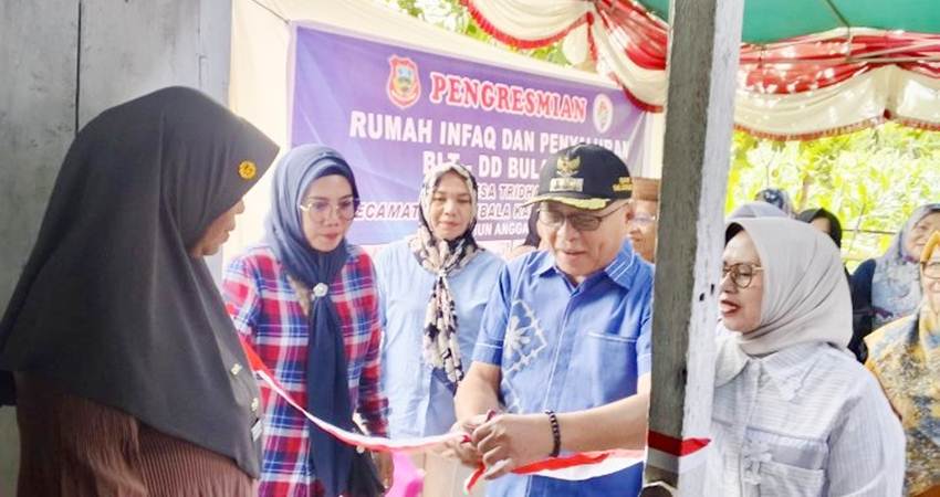 PERESMIAN. Bupati Gorontalo Sofyan Puhi saat melakukan penguntingan pita menandakan persemian rumah infaq di Desa Tridharma.