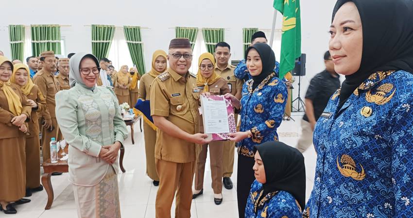 SIMBOLIS. Bupati Gorontalo Sofyan Puhi didampingi Ketua TP PKK Maryam Puhi Pago saat menyerahakan SK secara simbolis.