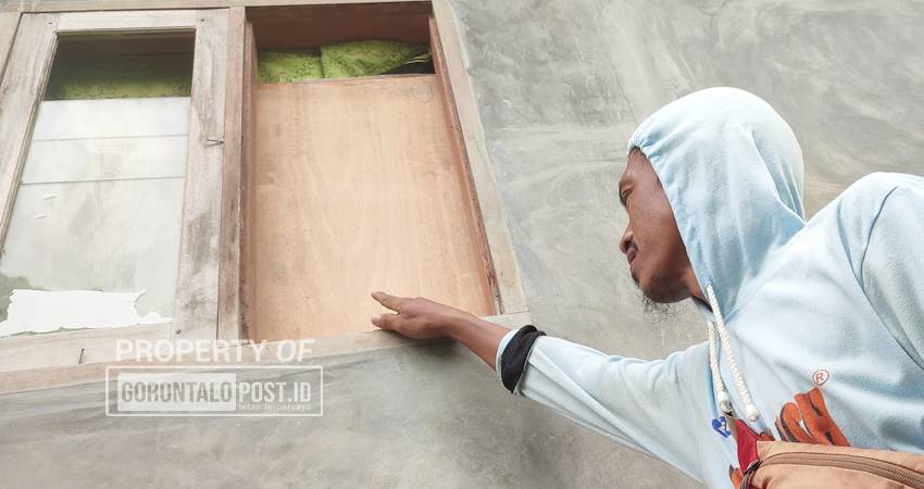 Djamaluddin Yusuf saat menjukkan tempat pelaku pencurian mencongkel jendela dan masuk ke rumahnya.Kamis(12/6). (Foto: Natharahman/Gorontalo Post)