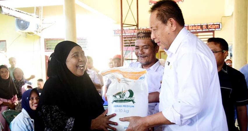 Gubernur Gusnar Ismail menyerahkan bantuan beras CPP di Desa Tuladenggi, Kecamatan Telaga Biru, Kabupaten Gorontalo, Rabu (23/7). (Foto : Haris /diskominfotik)