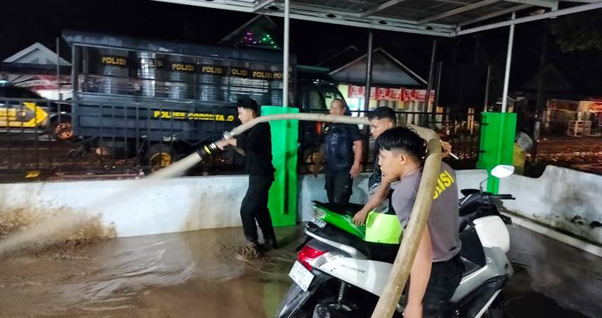 Sejumlah anggota Polri dan TNI bersama masyarakat pembersihan lumpur akibat banjir bandang di Kecamatan Limboto Barat. (foto : istimewa)