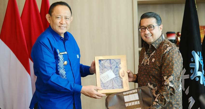 Gubernur Gorontalo Gusnar Ismail menyerahkan cinderamata berupa kain sulam karawo, salah satu potensi ekonomi kreatif kepada Menteri Ekonomi Kreatif, Teuku Riefky Harsya di Jakarta, Rabu (2/7). (foto : dok / pemprov)