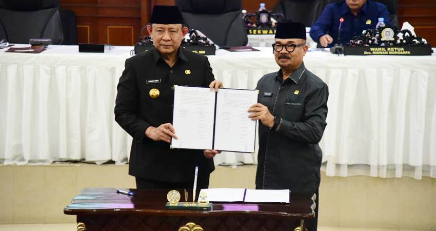 Gubernur Gorontalo Gusnar Ismail dan Ketua DPRD Provinsi Gorontalo Thomas Mopili menunjukan berita acara pengesahan Perda Pertanggungjawaban APBD pada Paripurna DPRD ke 28, Selasa (8/7). (foto : dok / pemprov)
