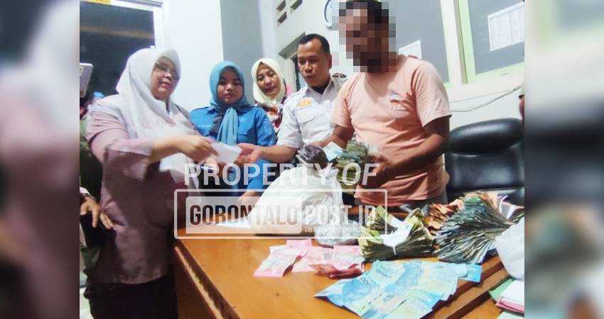 Lutfi Hariono bersama uang hasil mengemis di Kantor Satpol PP Kota Gorontalo, Kamis (3/7). (Foto : Natharahman/Gorontalo Post)