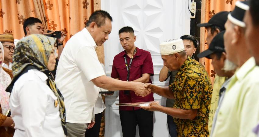 Gubernur Gorontalo Gusnar Ismail saat menyerahkan Sertifikat Hak Milik (SHM) di Kantor Camat Paguyaman Pantai, Kabupaten Boalemo, Rabu (16/7). (Foto – Ryan /Diskominfotik)