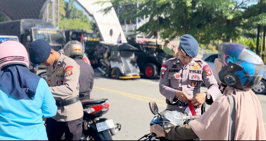 Personel Brimob Polda Gorontalo turun langsung ke jalan untuk membagikan bendera merah putih kepada para pengguna jalan.