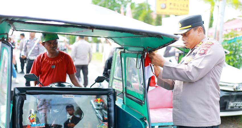 Kapolres Pohuwato, AKBP H. Busroni,S.I.K,M.H membagikan bendera merah putih kepada pengguna jalan.