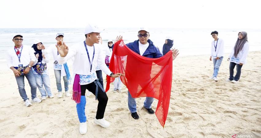 Kepala Kantor Perwakilan (KPw) Bank Indonesia (BI) Gorontalo Bambang Satya Permana (kanan) memperagakan tarian Saronde bersama peserta QRIS Jelajah Budaya Indonesia di Pantai Kurenai, Kabupaten Bone Bolango, Gorontalo, Sabtu (16/8). (ANTARA/Adiwinata Solihin)
