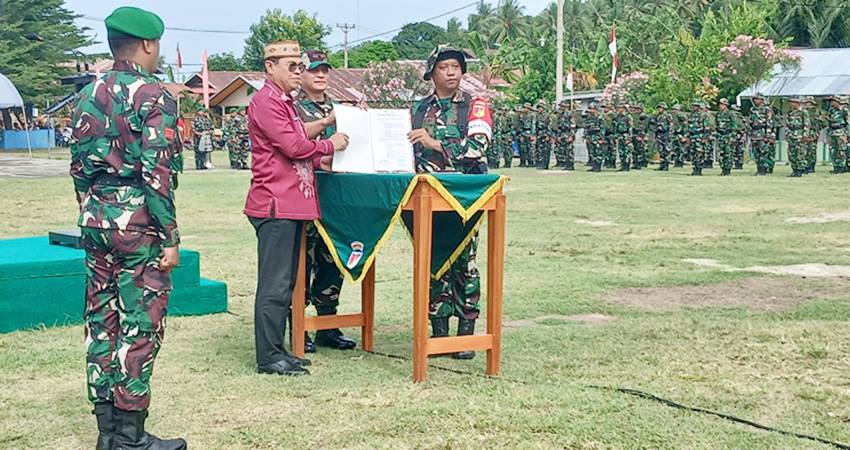 PENYERAHAN Naskah TMMD kepada pemerintah daerah setelah pelaksanaan operasi TMMD di Desa Molotabu, saat upacara penutupan, Kamis (21/8). (foto : caisar ntoma/ gorontalo post)
