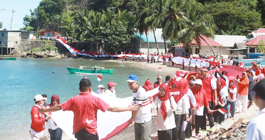 SEMARAH AGUSTUS - Forum Kewaspadaan Dini Masyarakat (FKDM) Provinsi Gorontalo, bersama masyarakat membentangkan merah putih sepanjang 1 KM, di Desa Modelomo, Kabila Bone, Bone Bolango, Sabtu (2/8). (foto : yudi-afik/humas-bonbol)