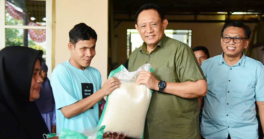 Gubernur Gorontalo Gusnar Ismail menyerahkan bantuan beras cadangan pangan pemerintah (CPP) daerah untuk keluarga penerima manfaat (KPM), Sabtu (6/9). (Foto – Ryan/Diskominfotik).