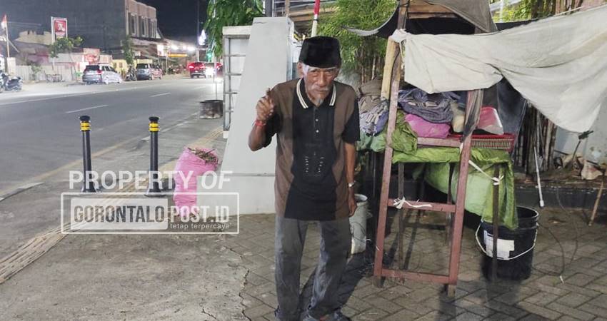 Seorang kakek yang membangun tenda di emperan jalan JA Katili (eks Andalas) Kota Gorontalo, Ahad (28/9/2005). (Foto: Roy/Gorontalo Post)