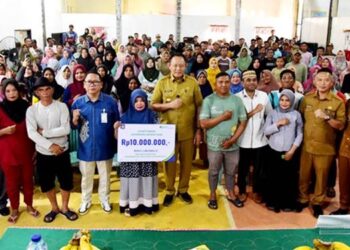 Foto bersama pekerja rentan penerima kartu BPJS Ketenagakerjaan dengan Gubernur Gusnar Ismail di aula Kantor Desa Tiohu, Kecamatan Asparaga, Kabupaten Gorontalo, Selasa (7/10/2025). (Foto : Haris/diskominfotik)