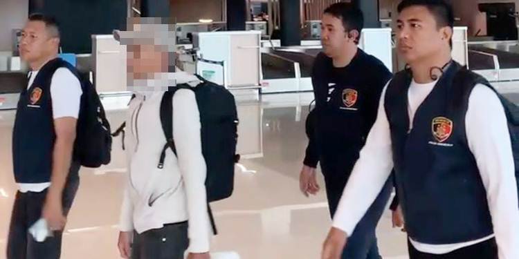 Tersangka dugaan korupsi proyek pemeliharaan Jalan Nani Wartabone Kota Gorontalo inisial RA (pakai topi) dikawal penyidik Ditreskrimsus Polda Gorontalo saat berada di Bandara Sultan Hasanudin Makassar.