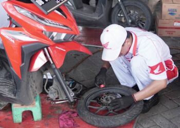 TERPERCAYA - Teknisi bengkel AHASS melakukan servis sepeda motor milik konsumen secara profesional. (foto: dok/daw)