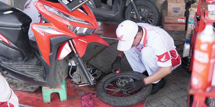 TERPERCAYA - Teknisi bengkel AHASS melakukan servis sepeda motor milik konsumen secara profesional. (foto: dok/daw)