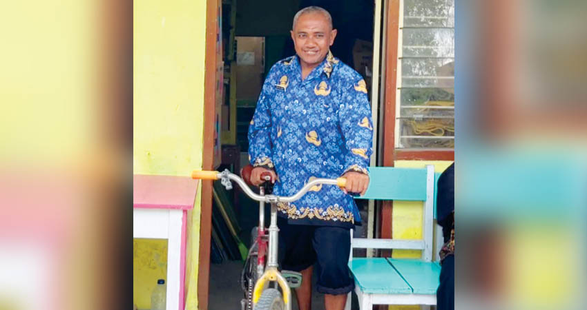 JADI PPPK - Sofyan Djusuf alias Ka Opi mengenakan batik Korpri dan sepeda tuanya di SD Negeri 6 Kota Barat, Kota Gorontalo, Rabu (1/10).