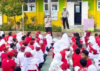 Kanit Kamsel, Aipda Fitrajaya Montu bersama anggota, memberikan edukasi kepada siswa sekolah dasar tentang tertib berlalu lintas.