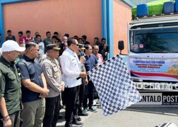 Gubernur Gorontalo Gusnar Ismail melepas truk pengangkut bantuan pangan untuk masyarakat Gorontalo ke seluruh wilayah dari gudang Bulog Gorontalo, Sabtu (15/11). (f0to: jitro paputungan / gorontalo post)