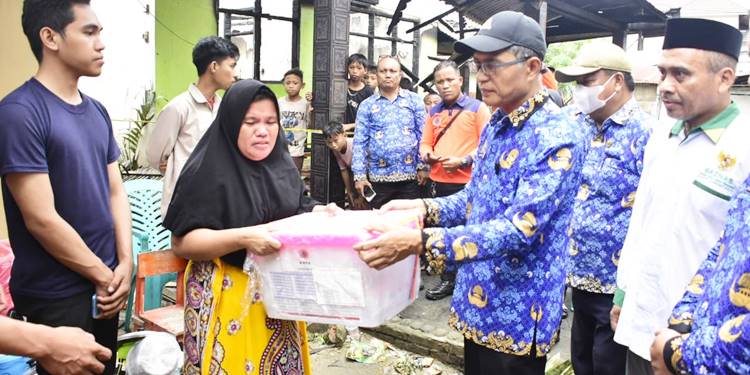Sekda Kota Gorontalo, Ismail Madjid ketika menyerahkan bantuan kepada korban musibah kebakaran, Jumat (14/11/2025). (Foto: Prokopim)