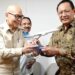 Gubernur Gorontalo Gusnar Ismail menerima cenderamata dari Komisaris Independen Garuda Indonesia, Glenny Kairupan, di Jakarta, Rabu (19/11). (Foto : istimewa/timko)