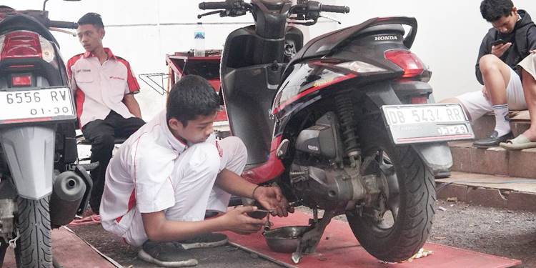 Teknisi bengkel resmi Honda saat sedang melakukan servis sepeda motor konsumen. (foto: dok/daw)