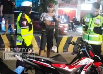Personel Satuan Lalu Lintas Polresta Gorontalo Kota, mengamakan sejumlah motor balap liar di Bundaran Saronde Kota Gorontalo, dini hari, Ahad (2/11). (F. Natharahman/ Gorontalo Post)