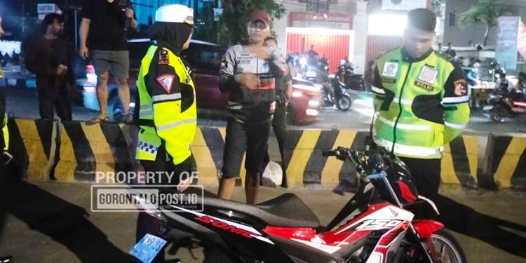 Personel Satuan Lalu Lintas Polresta Gorontalo Kota, mengamakan sejumlah motor balap liar di Bundaran Saronde Kota Gorontalo, dini hari, Ahad (2/11). (F. Natharahman/ Gorontalo Post)